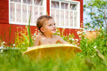 Bathing of the child in a yellow plastic bathの写真素材