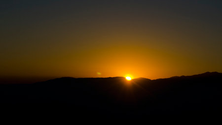 The sun rises over the mountains.の写真素材