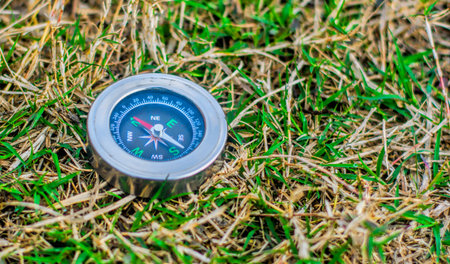 Photo of a steel compass on the grassの写真素材