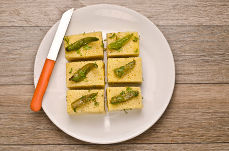 Photo of Gujrati dish Dhokla in a plate with a knife.の写真素材