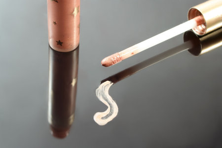 smudge of beige lip gloss, applicator, and tubeの写真素材