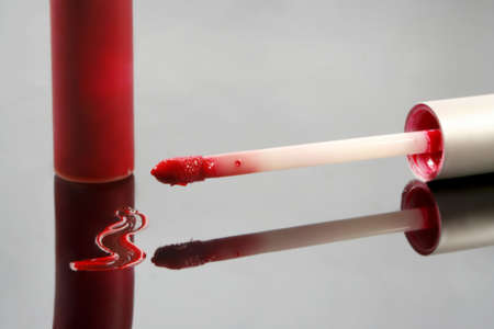 smudge of red lip gloss, applicator, and tubeの写真素材