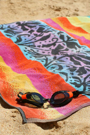 sandy beach with goggles and towelの写真素材