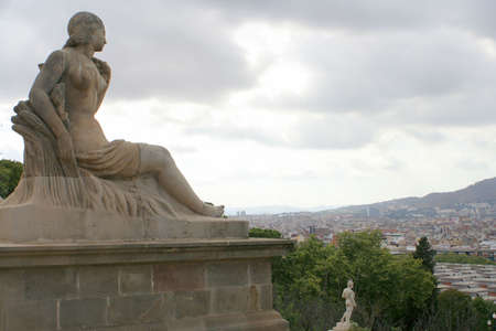 Statue in Montjuic overlooking Barcelona skylineの写真素材
