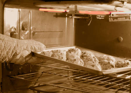 putting cookies in oven for bakingの写真素材