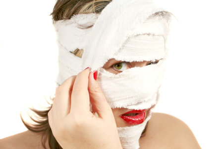 woman unwrapping  bandages on the  after plastic surgeryの写真素材
