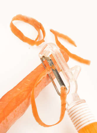 using carrot peeler to remove carrot skinの写真素材