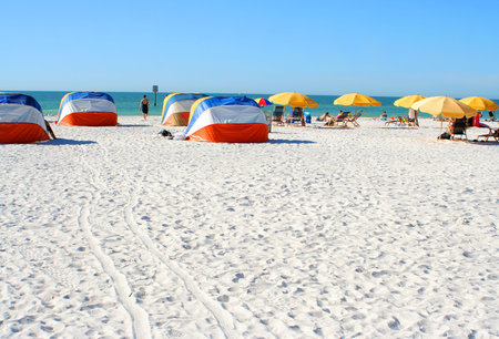 people relaxing on beach chairs under umbrellas in Clearwater Beach, Florida, USAの写真素材