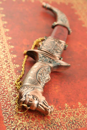 decorative asian knife with horses head and shieldの写真素材