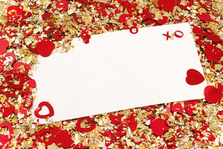 blank card on valentine confetti make of hearts and gold glitter