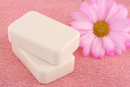 pink daisy with soaps on top of pink towel