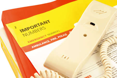 home telephone on top of phone directories and emergency numbersの写真素材