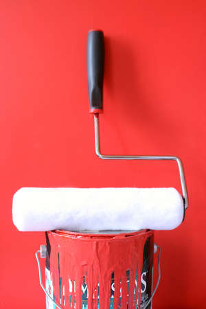 paint roller on top of  red paint can for home decoratingの写真素材