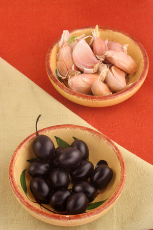two dishes with black olives and garlic の写真素材