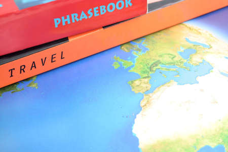 world map with travel and phrase books on top with copyspaceの写真素材
