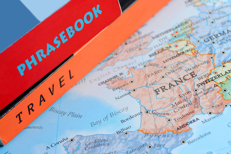 world map with travel and phrase books on top の写真素材