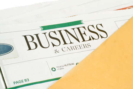 business section of the newspaper with yellow envelopeの写真素材