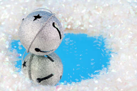 silver bells with reflection surrounded by fake snowの写真素材