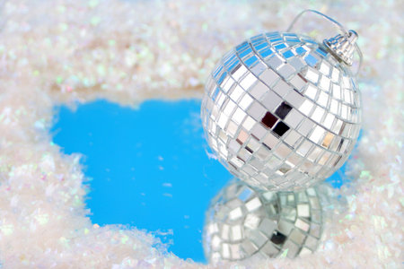 disco ball decoration with reflection surrounded by fake snowの写真素材