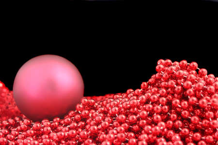 cluster of red stringed sparkling christmas beads on black backgroundの写真素材