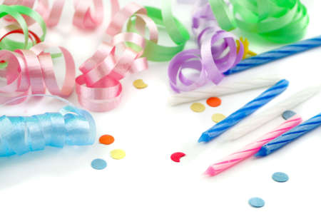 colorful ribbons,confetti, and birthday cake candles over whiteの写真素材