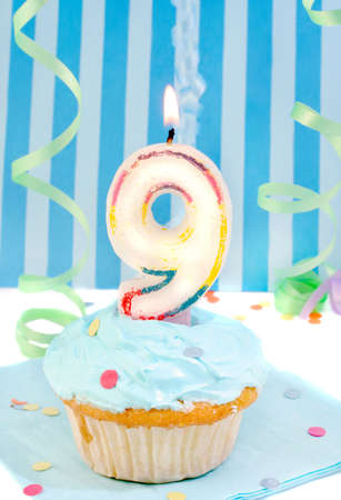  boy's ninth birthday cupcake with blue frosting and  decorative background の写真素材