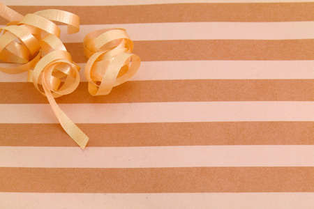 fall colors striped background with curled ribbon which could be the top of a present box or wrapping paperの写真素材