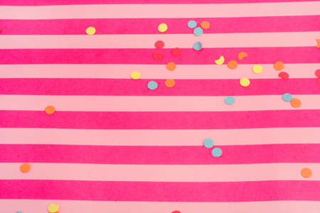 pink striped background with confetti great for partiesの写真素材