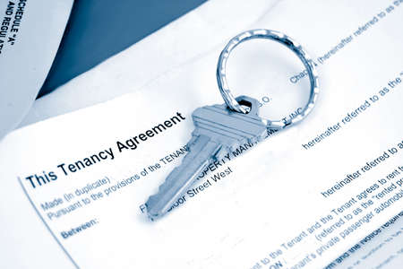 some paperwork concerning tenancy agreement with key in blue toneの写真素材