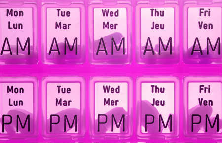 different kinds of pills in slots of  daily reminder cannisterの写真素材