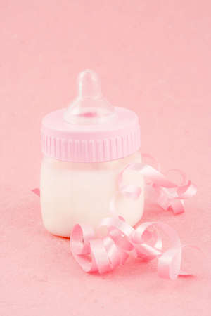 a pink  bottle with milk and celebratory ribbon suitable for new の写真素材