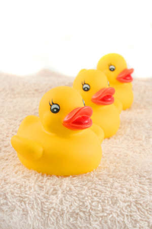 three child's rubber duck on top of towel ready for bath timeの写真素材
