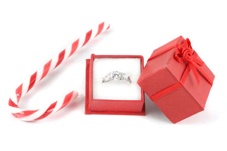 christmas candy cane with small red gift box holding a diamond engagement ringの写真素材