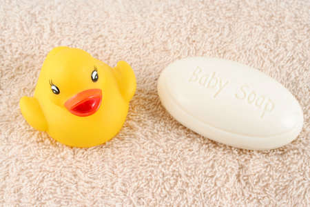 baby soap and rubber duck on a towel ready for bathingの写真素材