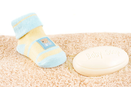 baby sock and soap on top of a towel 