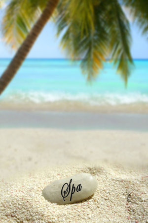 a spa stone in the sand on a tropical beach         