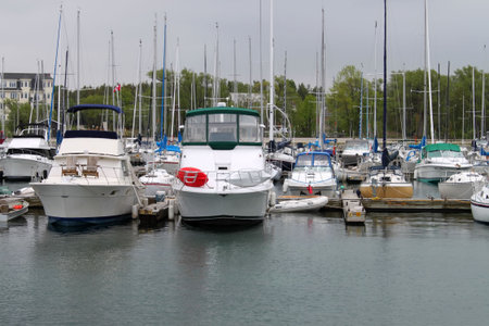 Sailing boats docked in marina under cloudy skies