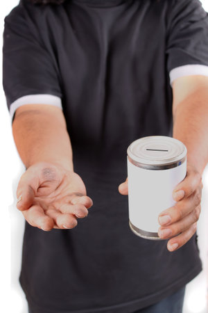 Homeless man with dirty hands holds a tin can asking for change 