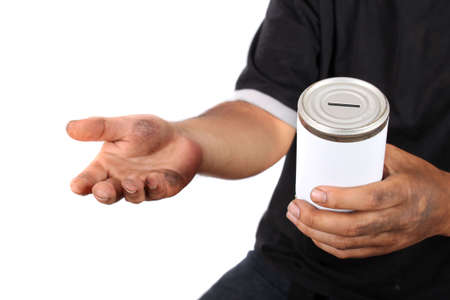 Homeless man with dirty hands holds a tin can with blank label asking for change の写真素材
