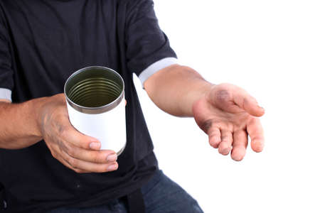 Homeless man with dirty hands holds a tin can asking for change の写真素材