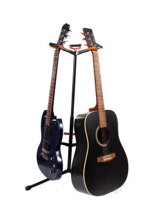 Accoustic and electric guitars on a stand with a white backgroundの写真素材