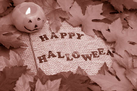 happy halloween background with leaves covering twine rope paper and lit jack-o-lantern の写真素材