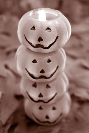 lit stack of jack-o-lantern scene on fall leaves の写真素材