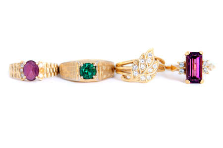 different colored stone rings with gold bands in a white backgroundの写真素材