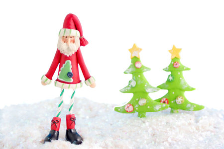 slim santa claus christmas decoration on fake snow and white background 