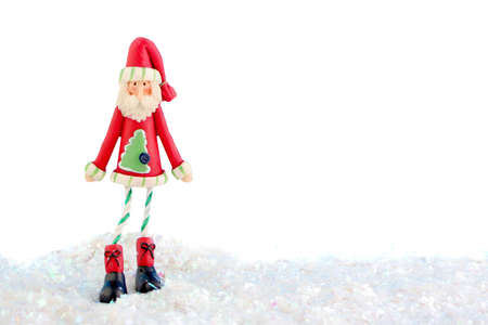 slim santa claus christmas decoration on fake snow and white background の写真素材