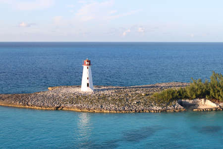 Lighthouse amongst turquoise blue sea at the entrance of the harbor in Nassau, Bahamasの写真素材