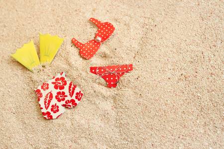 Men's and women's bathing suits in beach sand, great for a summer backgroundの写真素材