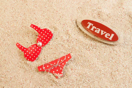 Women's red bikini in beach sand, great for a summer travel backgroundの写真素材