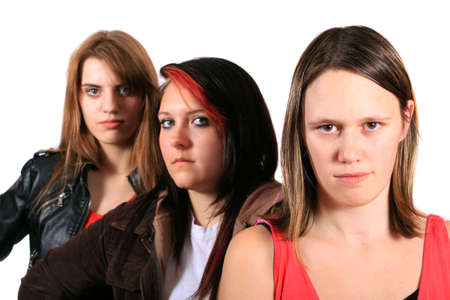 Three pretty teenaged girlfriends with serious look hanging out on a white backgroundの写真素材